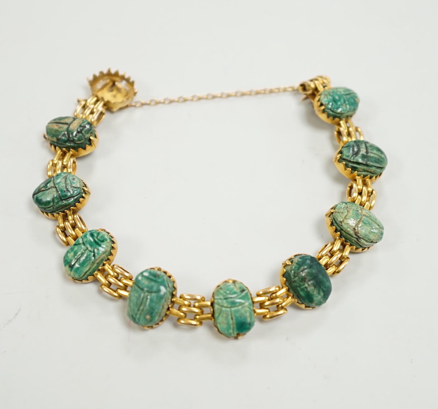 An early 20th century 9ct and ten stone ceramic scarab set bracelet (one stone loose), approx. 17cm, gross weight 20.3 grams.